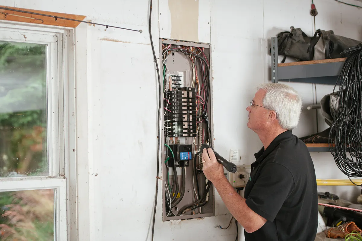 An electrician inspecting a home fuse box
